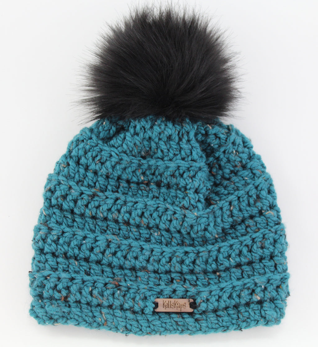 The Kells Beanie in Teal Tweed with a Black Faux Fur Pom